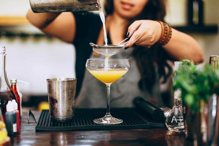 Woman pouring a drink, bartender is one of the worst jobs for introverts